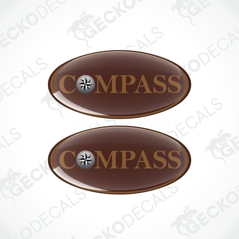 Two brown oval-shaped vinyl decals with the word 'COMPASS' printed on them, including a compass symbol within the text.