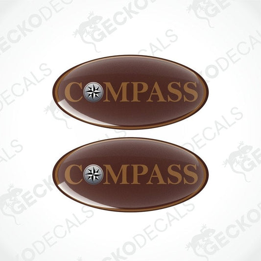 Two brown oval-shaped vinyl decals with the word 'COMPASS' printed on them, including a compass symbol within the text.