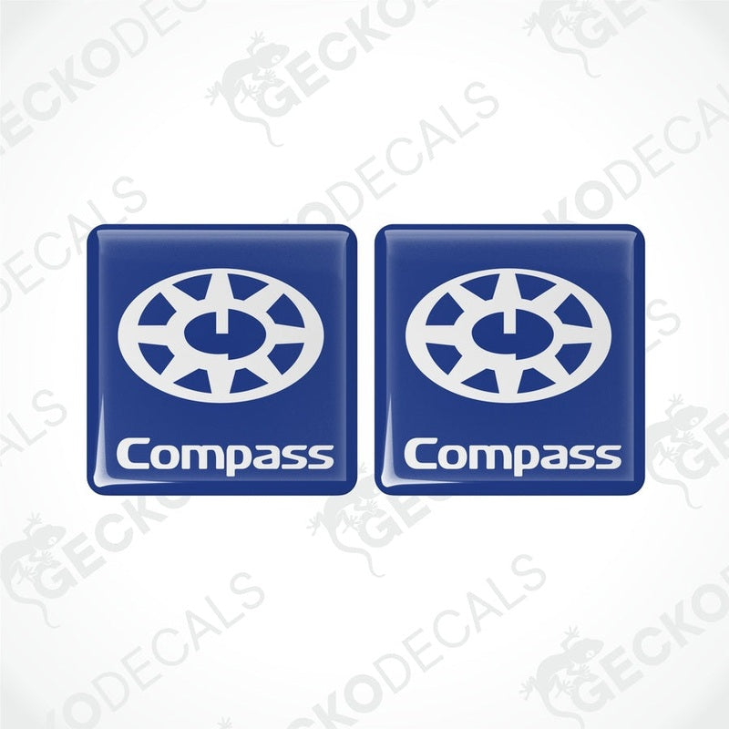 Two blue square decals with the word 'Compass' and a compass rose design in white.