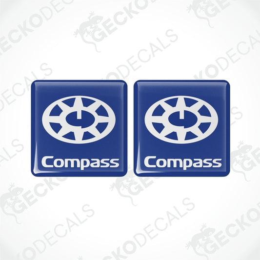 Two blue square decals with the word 'Compass' and a compass rose design in white.