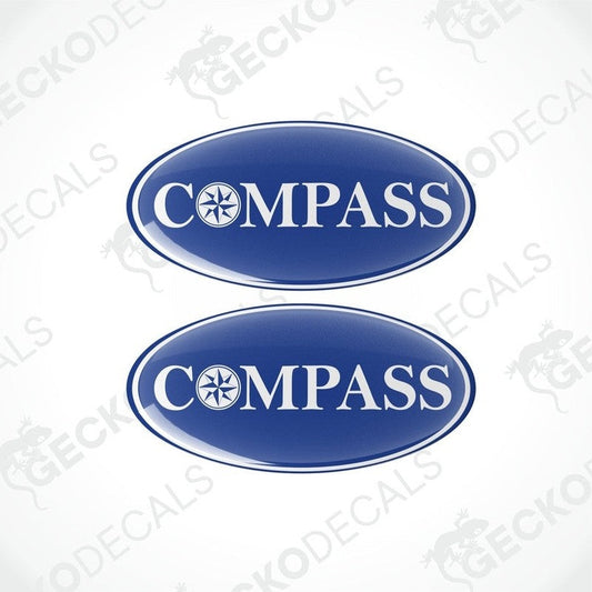 Two blue vinyl decals with the word 'COMPASS' written on them, placed against a white background.