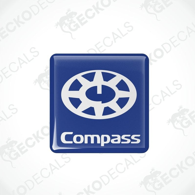Two blue square decals with the word 'Compass' and a compass rose design in white.