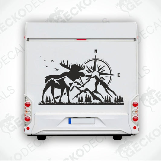 A white vehicle decal featuring a black moose with a compass in the center, surrounded by a forest and mountain landscape.