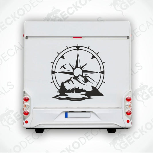 A white vehicle decal with a compass design, mountains, and a sun motif.