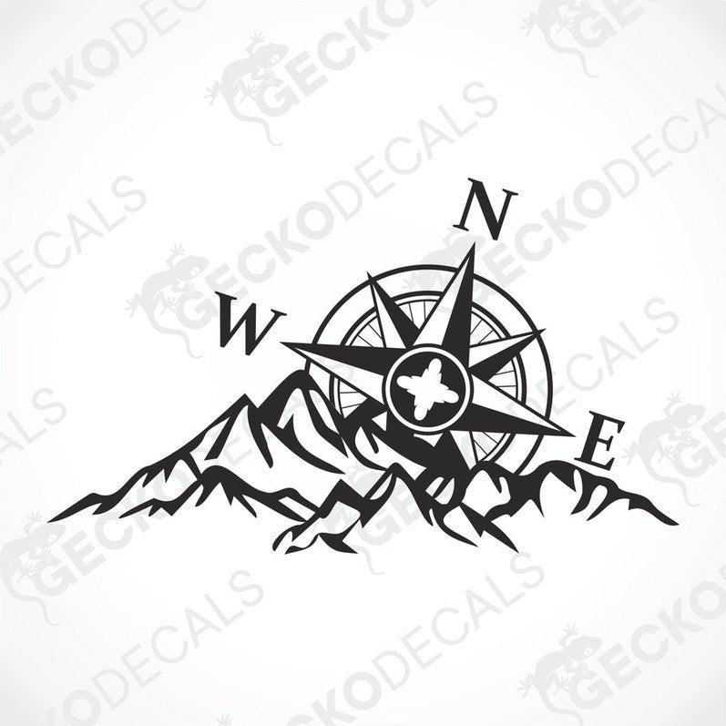 A white caravan with a black decal featuring a compass and mountains. The decal is positioned on the rear side of the caravan, near the window.