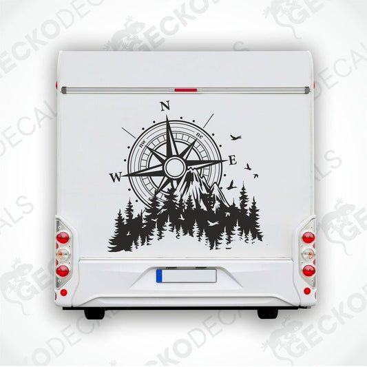 A black and white decal of a compass with mountains and trees on a vehicle.