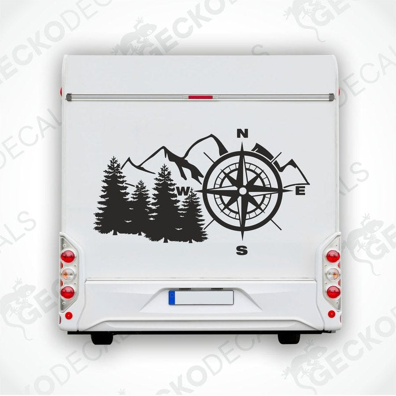 A white vehicle decal featuring a black compass design with mountains and a tree backdrop.