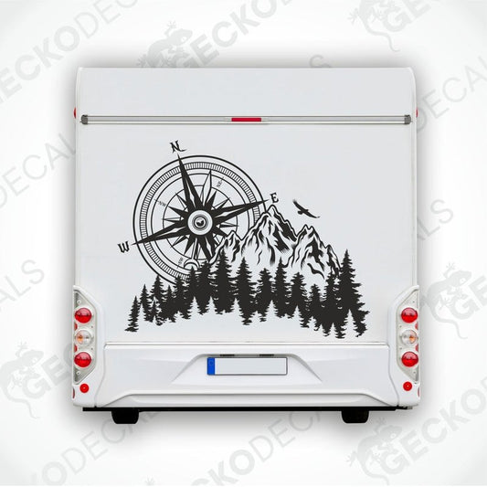 A white car decal with a compass design, mountains, and pine trees.