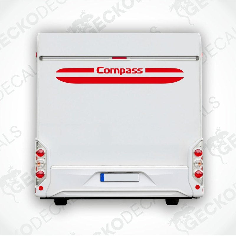 A white caravan with a red and white compass decal on the rear side.