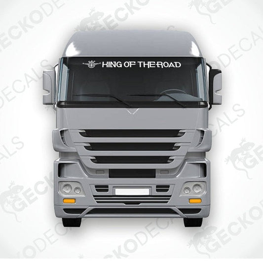 A die cut decal with the phrase 'KING OF THE ROAD' printed on it, positioned on the front windshield of a gray truck.
