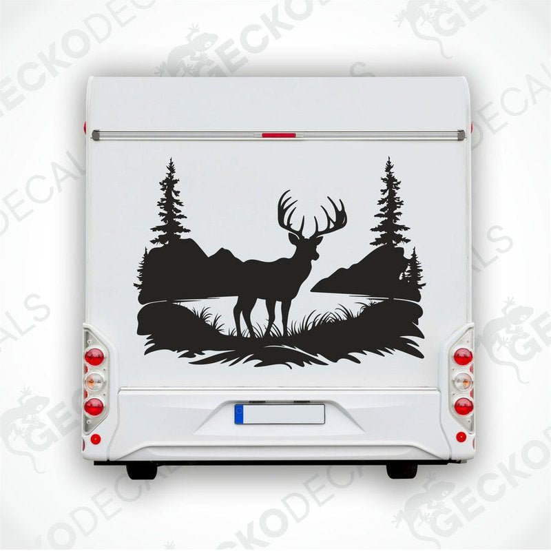 A black decal of a deer in a natural setting with trees and a sky background, positioned on the side of a white vehicle.