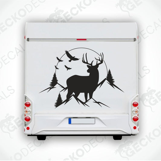 A decal featuring a silhouette of a deer in a mountainous landscape with trees and a sunset.