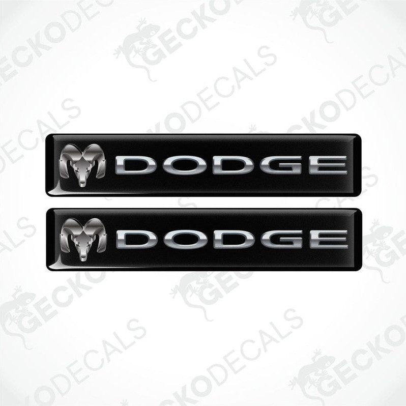 Two black vinyl stickers with the word 'Dodge' printed on them.
