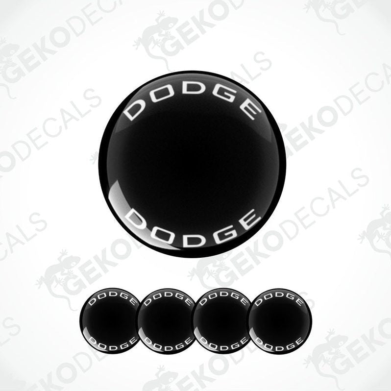 A set of black vinyl decals with the word 'DODGE' written in white letters, designed for use as car wheel caps or stickers.