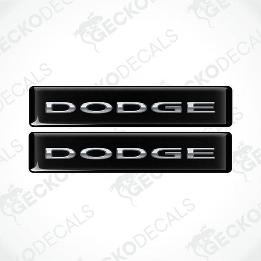 Two black vinyl decals with the word 'DODGE' written in silver letters.