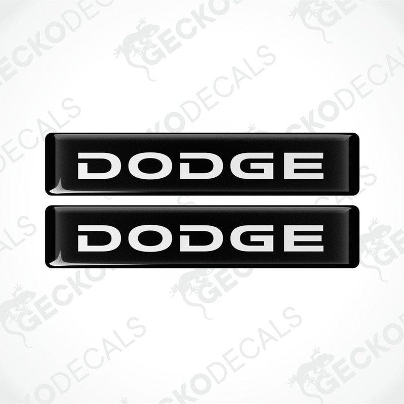 Two black and white vinyl decals with the word 'DODGE' printed on them.