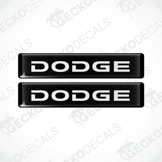 Two black and white vinyl decals with the word 'DODGE' printed on them.