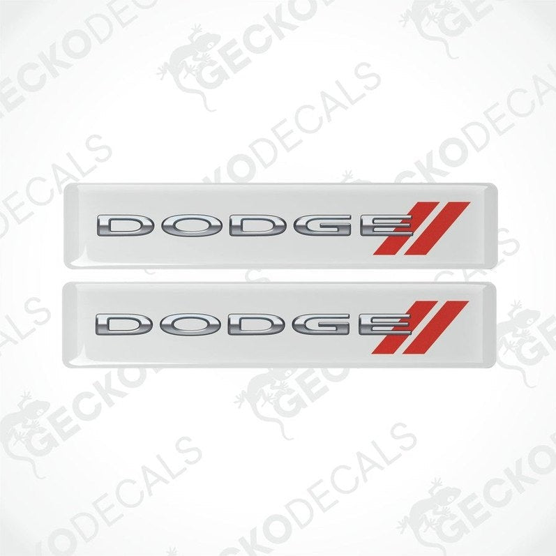 Two white vinyl stickers with the word 'DODGE' and a red and silver logo design on them.
