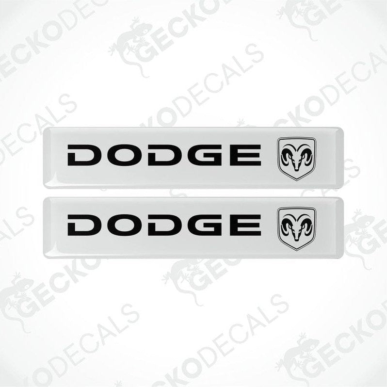 Two white vinyl decals with the Dodge brand logo in black.