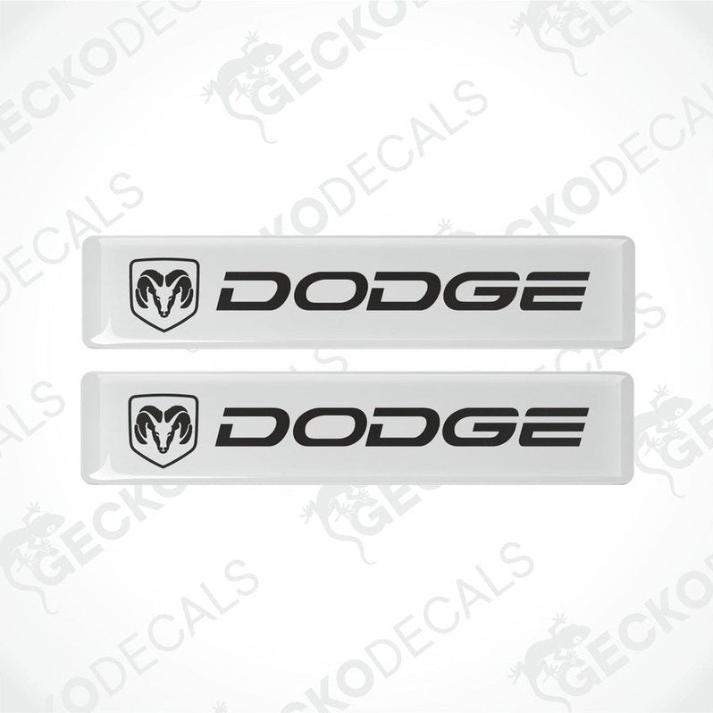Two white vinyl decals with the Dodge logo in black.
