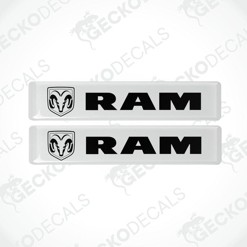 Two white vinyl decals with the RAM logo on them, intended for use as car stickers.