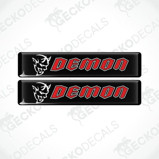 Two black vinyl stickers with the word 'DEMON' written in red. One sticker has a graphic of a demon above the text, and both are branded with 'GECKODECALS'.