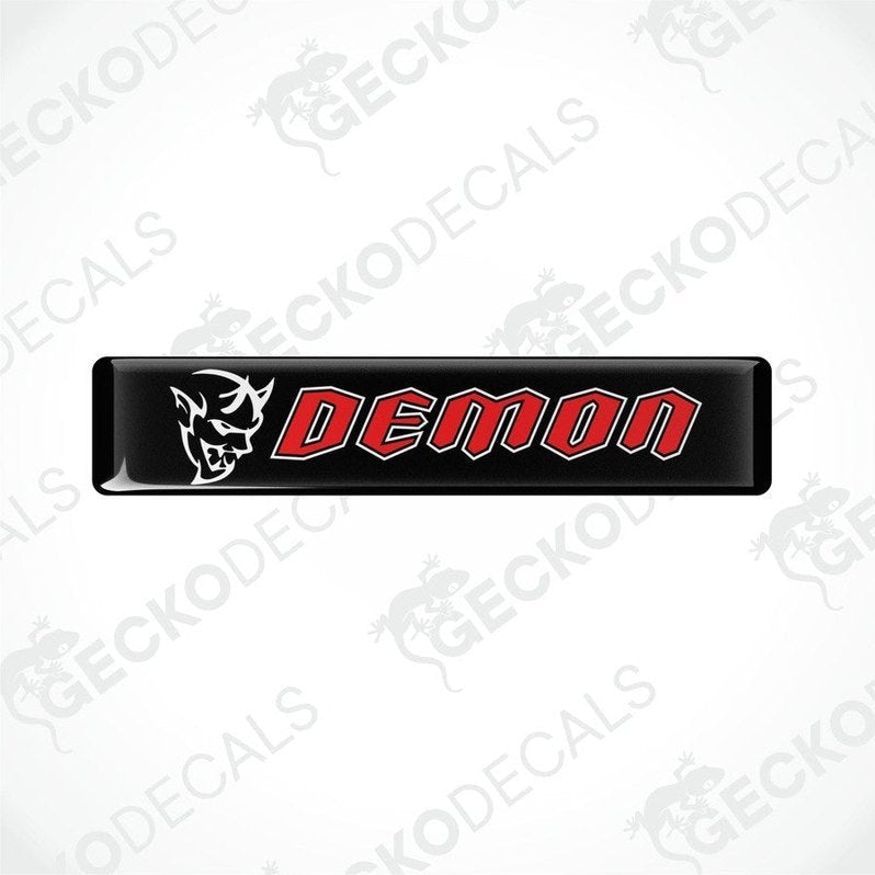 Black vinyl stickers with the word 'DEMON' written in red. One sticker has a graphic of a demon above the text, and both are branded with 'GECKODECALS'.