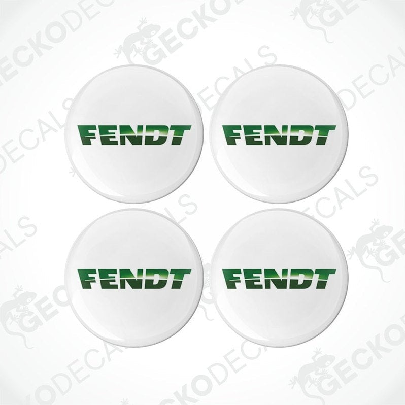 A set of four white round decals with the green text 'FENDT' on them, arranged in a square formation.