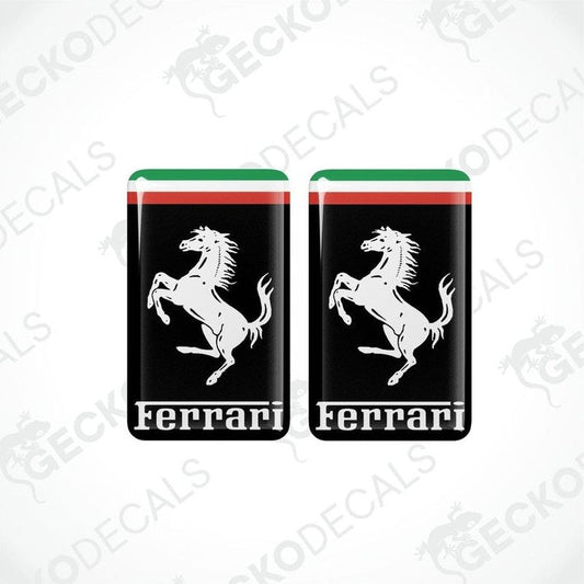 Two vinyl stickers with a depiction of a horse and the Ferrari logo on a black background with red and green stripes.