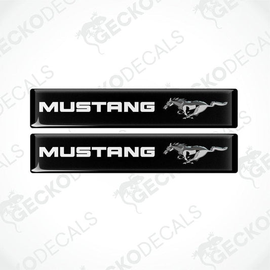 Two black vinyl stickers with the word 'MUSTANG' and an image of a horse and rider on them, placed against a white background.