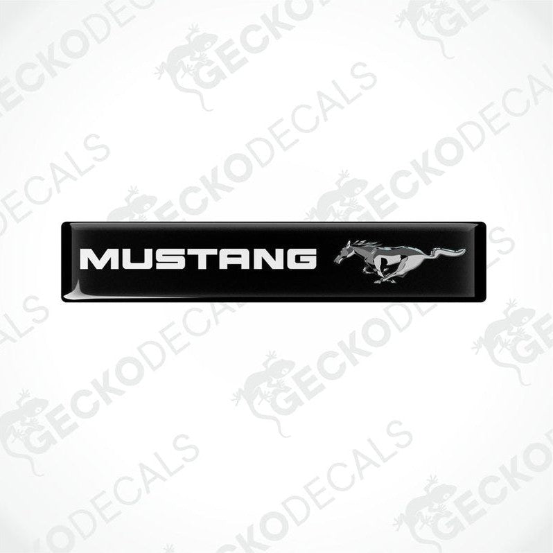 Black vinyl stickers with the word 'MUSTANG' and an image of a horse and rider on them, placed against a white background.
