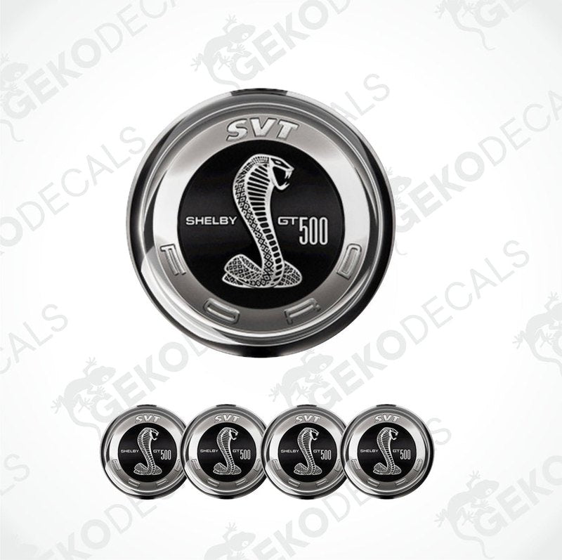 A set of four silver-colored vinyl stickers with a Shelby GT 500 logo, designed for use on car wheels or caps.