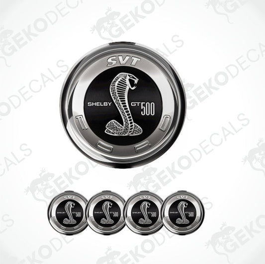 A set of four silver-colored vinyl stickers with a Shelby GT 500 logo, designed for use on car wheels or caps.