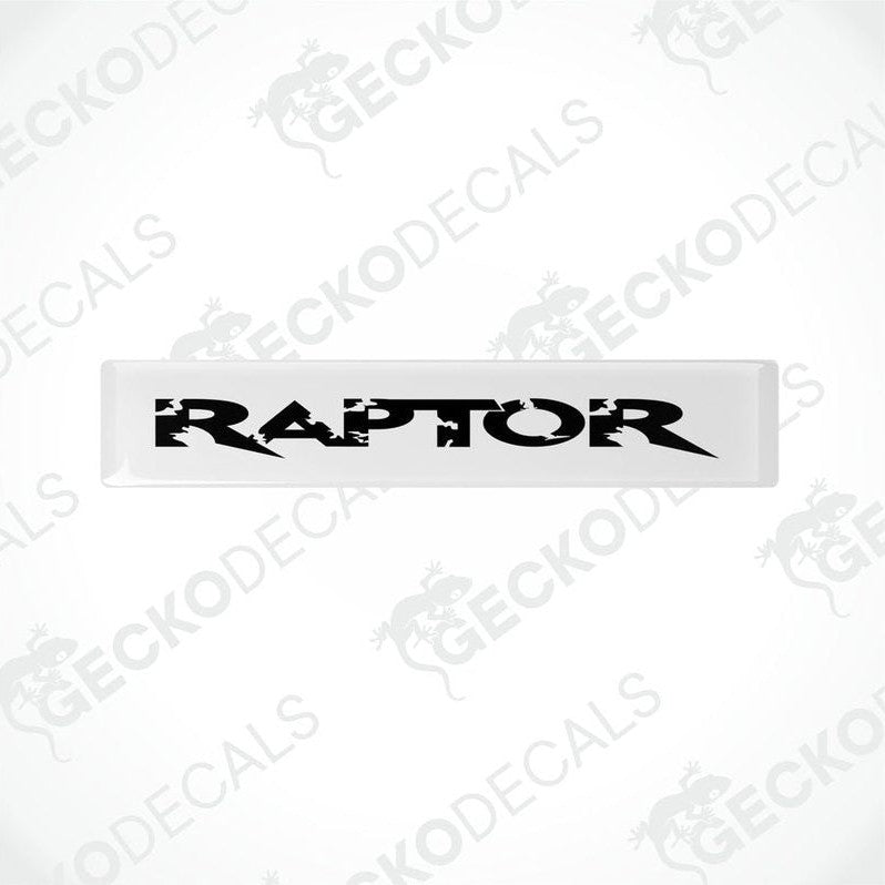  White and black rectangular car decals with the word 'RAPTOR' written on them in bold lettering.