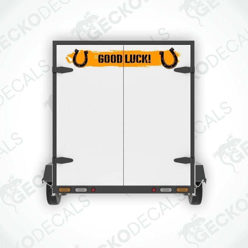 A white vehicle decal with the text 'GOOD LUCK!' and a pair of black horse shoes on it.