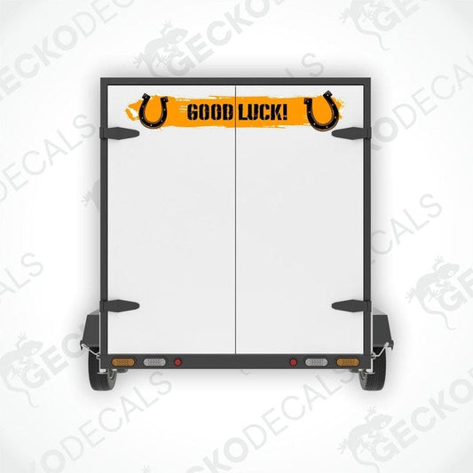 A white vehicle decal with the text 'GOOD LUCK!' and a pair of black horse shoes on it.