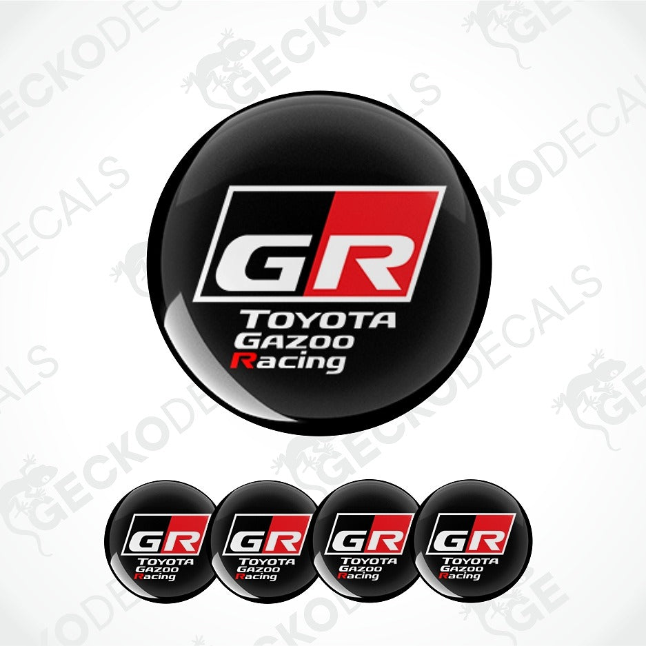 A set of circular black decals featuring the Toyota Gazoo Racing GR logo, with one large decal shown above four smaller identical decals on a white background with faint watermark patterns.