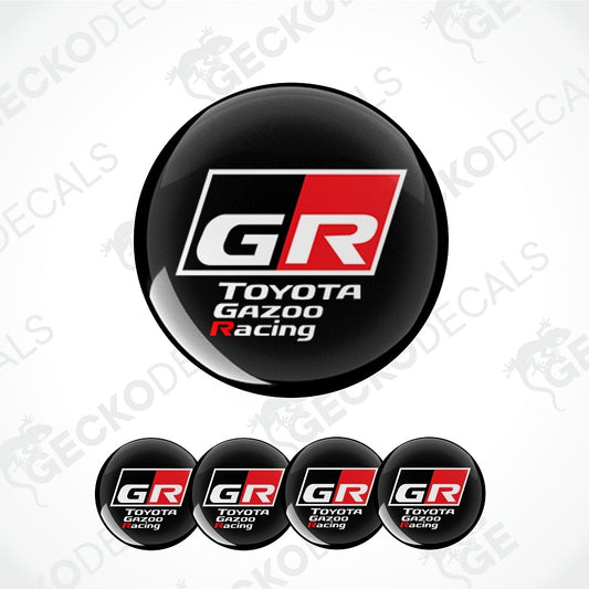 A set of circular black decals featuring the Toyota Gazoo Racing GR logo, with one large decal shown above four smaller identical decals on a white background with faint watermark patterns.
