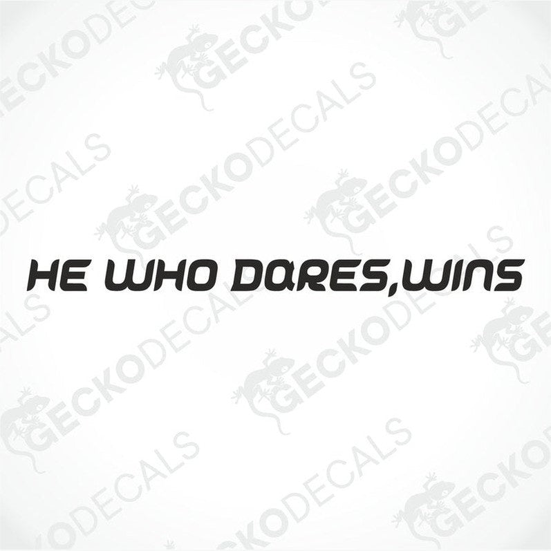 A die cut decal with the phrase 'HE WHO DARES, WINS' positioned on the front window of a gray truck.