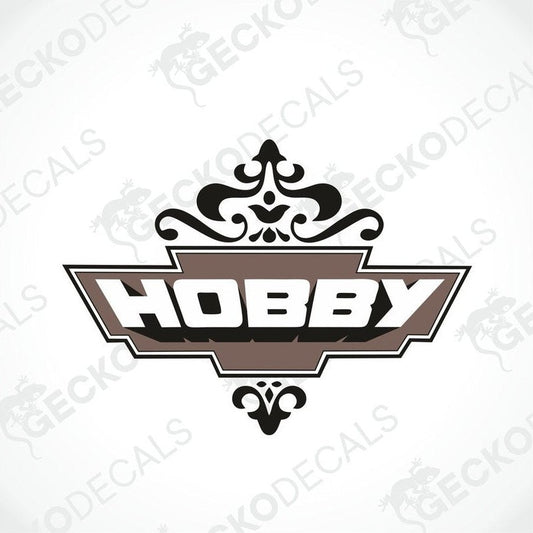 A die cut sticker with the word 'HOBBY' printed in a decorative font, predominantly brown and white in color, with a cut-out shape around the text.