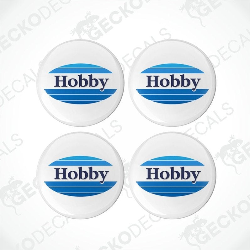 Four white, blue, and gray dome-shaped epoxy decals with the word 'Hobby' printed on them.