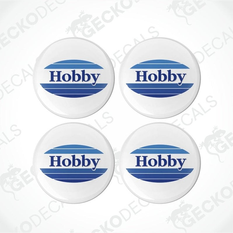 A set of four white vinyl decals with the word 'HOBBY' in blue and red text, placed on a white background.