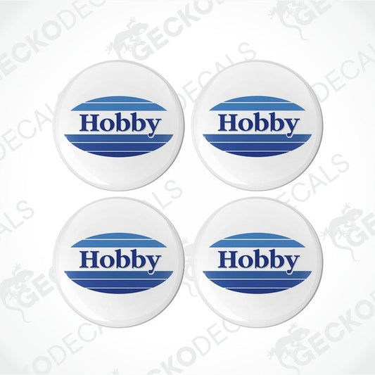 A set of four white vinyl decals with the word 'HOBBY' in blue and red text, placed on a white background.