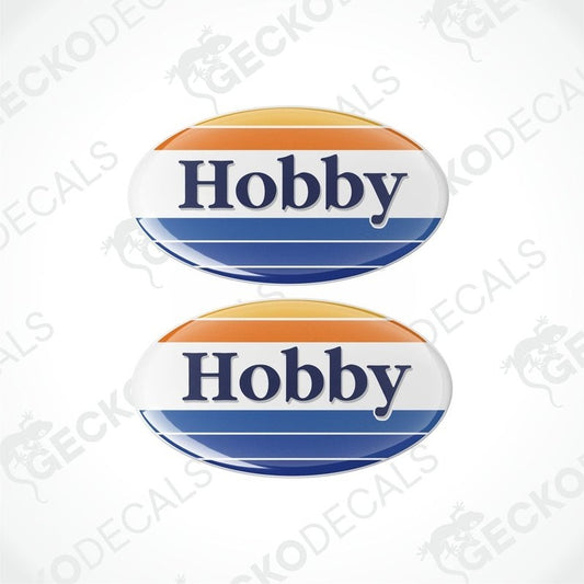 Two round vinyl decals with the word 'HOBBY' in bold letters, one above the other. The decals have a blue background with an orange and white border.