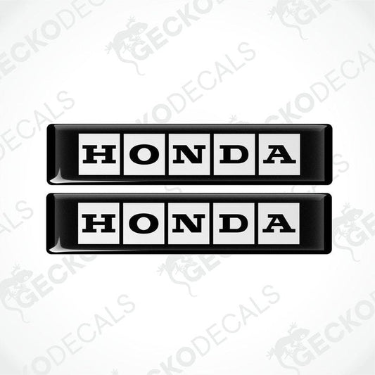 Two rectangular black and white vinyl decals with the text 'HONDA' displayed on them.