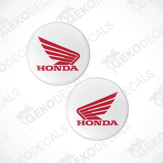 Two Honda logos on white circular stickers with a brand watermark.