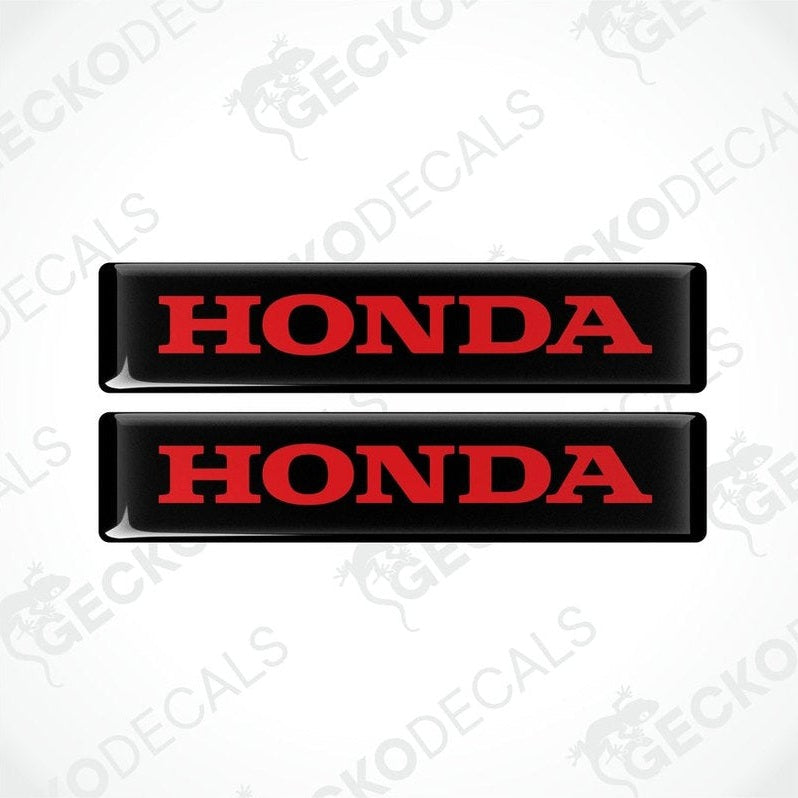 Two rectangular black vinyl decals with the word 'HONDA' written in bold red letters.
