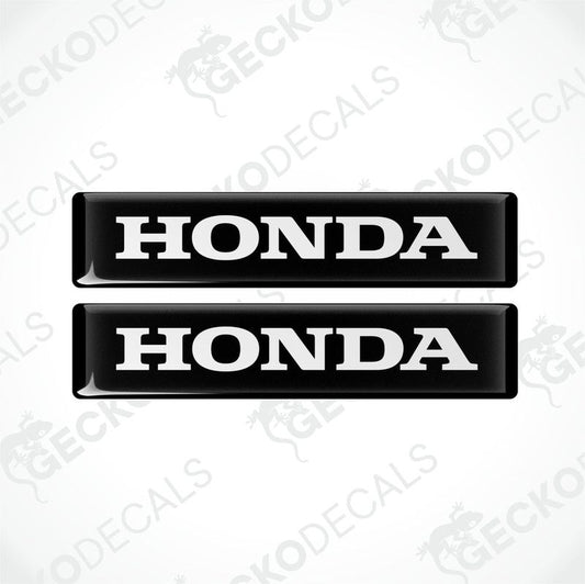 Two black and white rectangular car decals with the text 'HONDA' on them.
