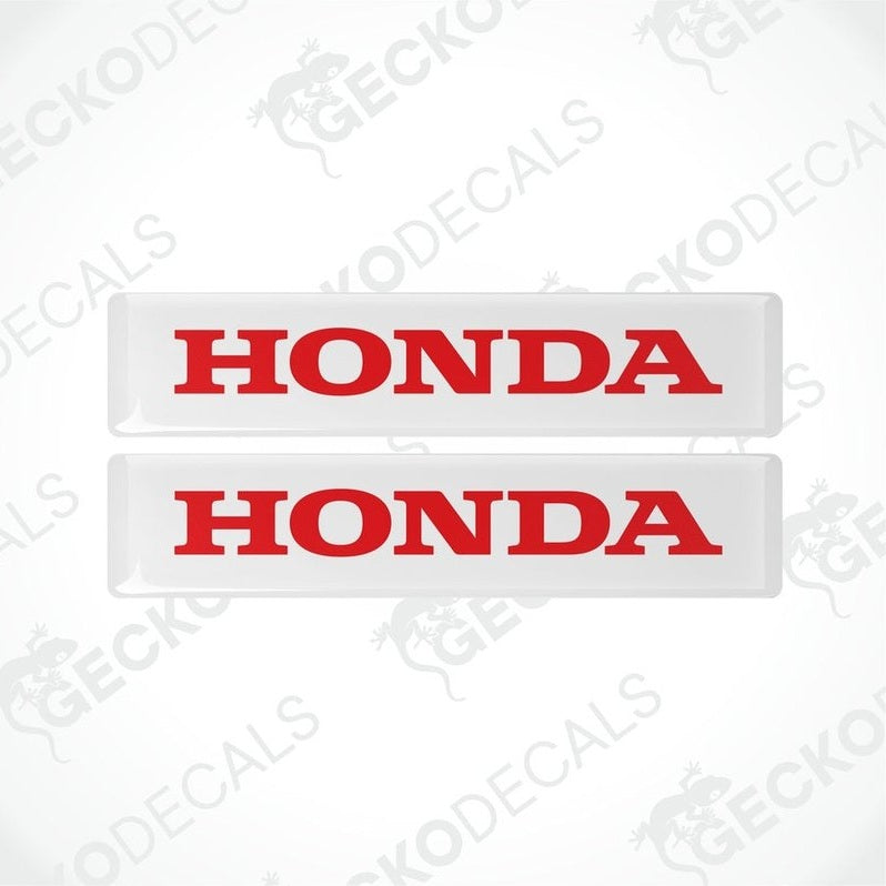 Two rectangular white vinyl decals with the word 'HONDA' written in bold red letters.