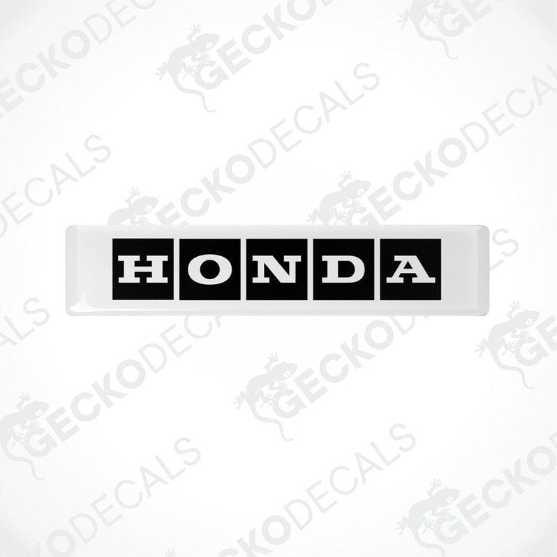 Rectangular white and black vinyl decals with the text 'HONDA' displayed on them.